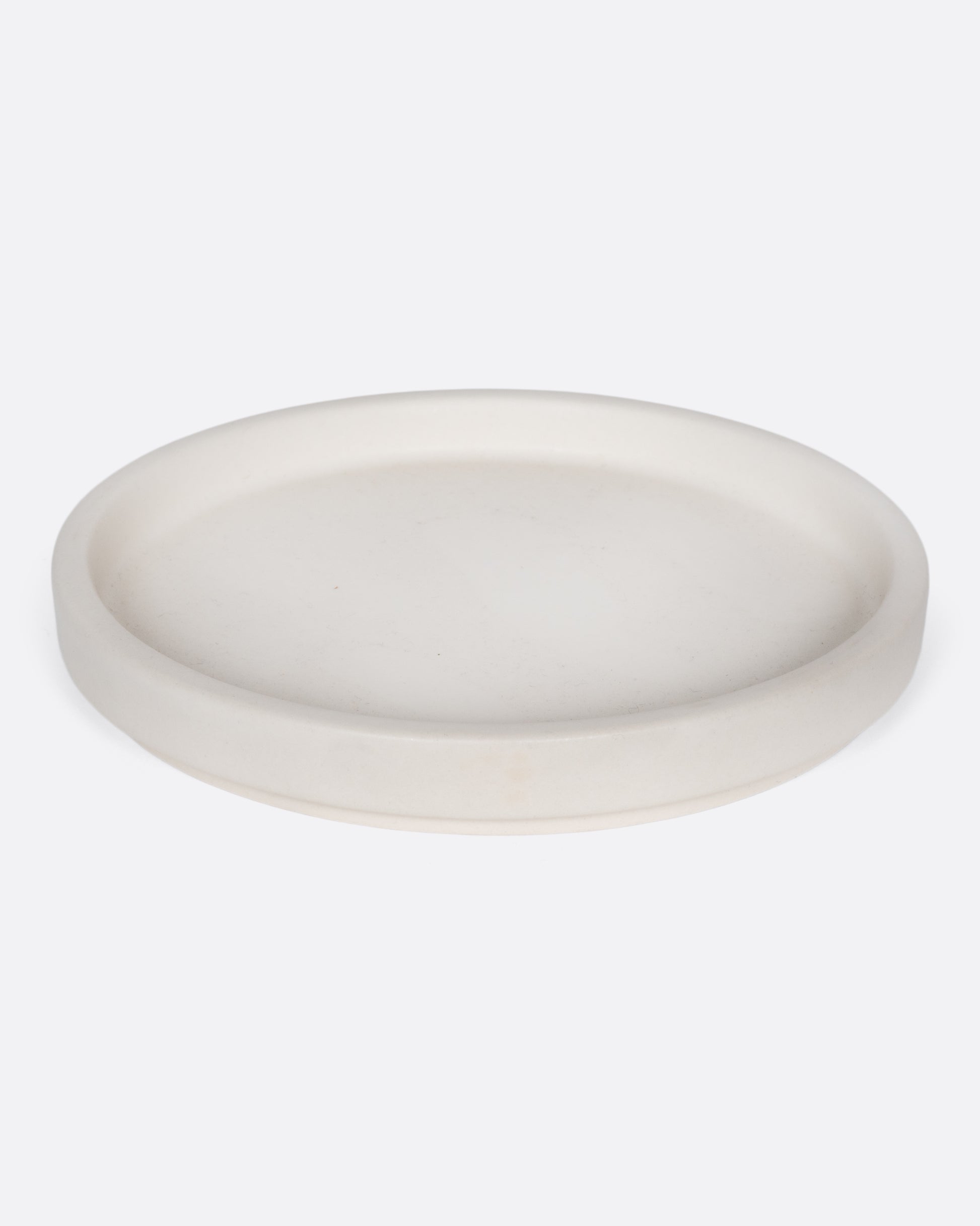 This creamy white ceramic plate with a raised lip and matte white finish looks beautiful with tall candles and works great for small plants, too.