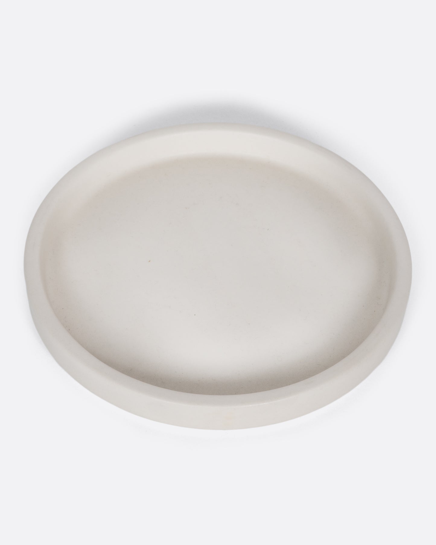 This creamy white ceramic plate with a raised lip and matte white finish looks beautiful with tall candles and works great for small plants, too.