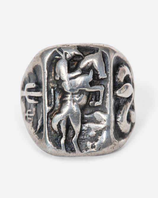 A vintage sterling silver cowboy ring with a bucking bronco in the center and desert scenes carved into the sides