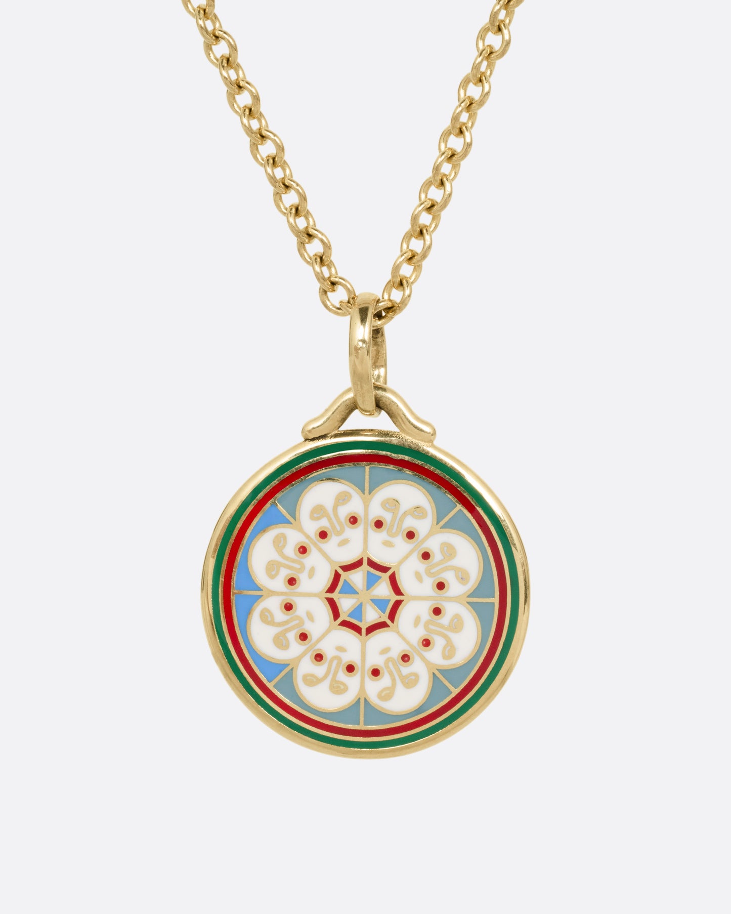 A yellow gold necklace with a circular pendant hanging from it, on it is a circle of white faces in enamel. Shown from the front.