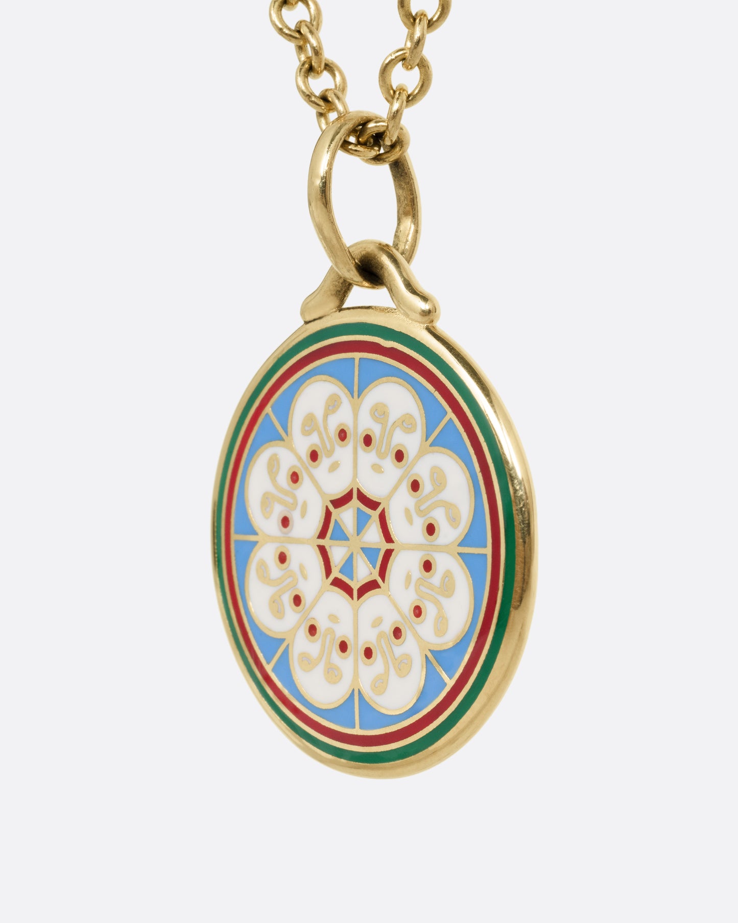 A yellow gold necklace with a circular pendant hanging from it, on it is a circle of white faces in enamel. Shown from the side.