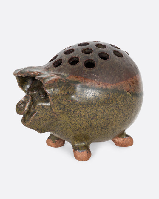 A green ceramic frog flower vase that's a pig! Shown from the side.