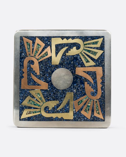 An alpaca silver box with copper and brass geometric inlay and sodalite chips as the blue background. Shown from the front.