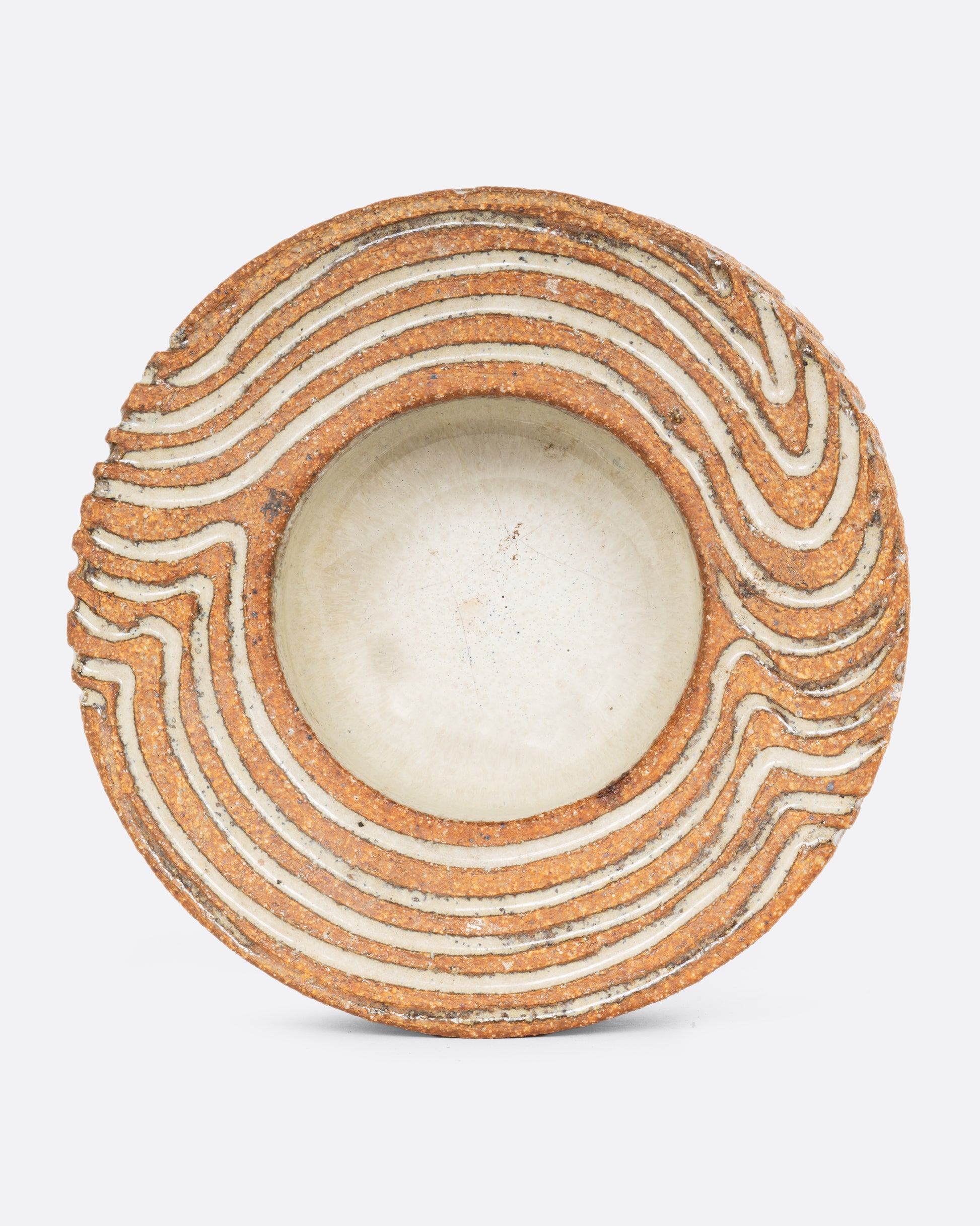 A chunky round ceramic bowl with hand drawn wavy line design throughout. Shown straight on of the top.