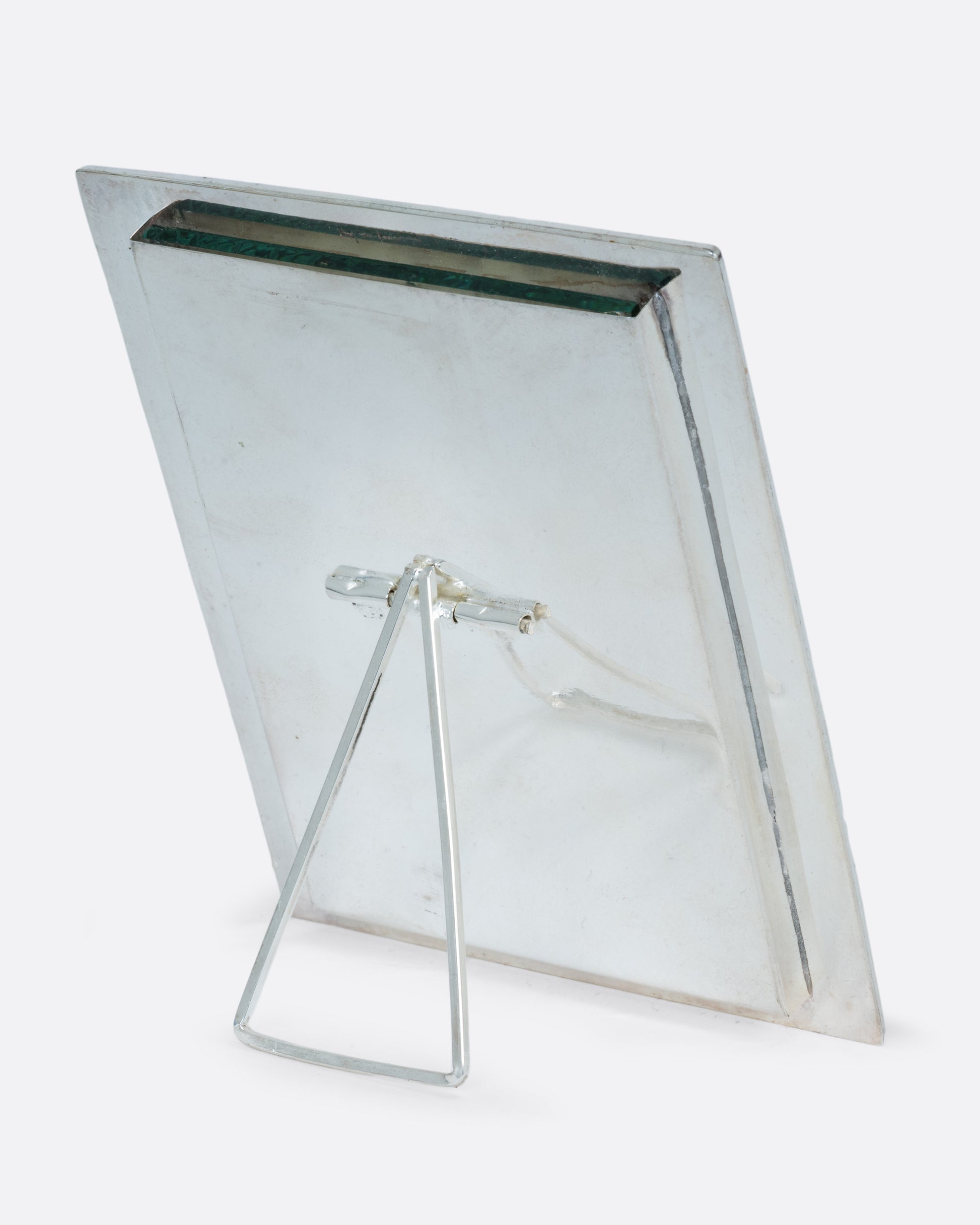 A silver rectangular picture frame with abalone inlay. Shown standing up at an angle from the back.
