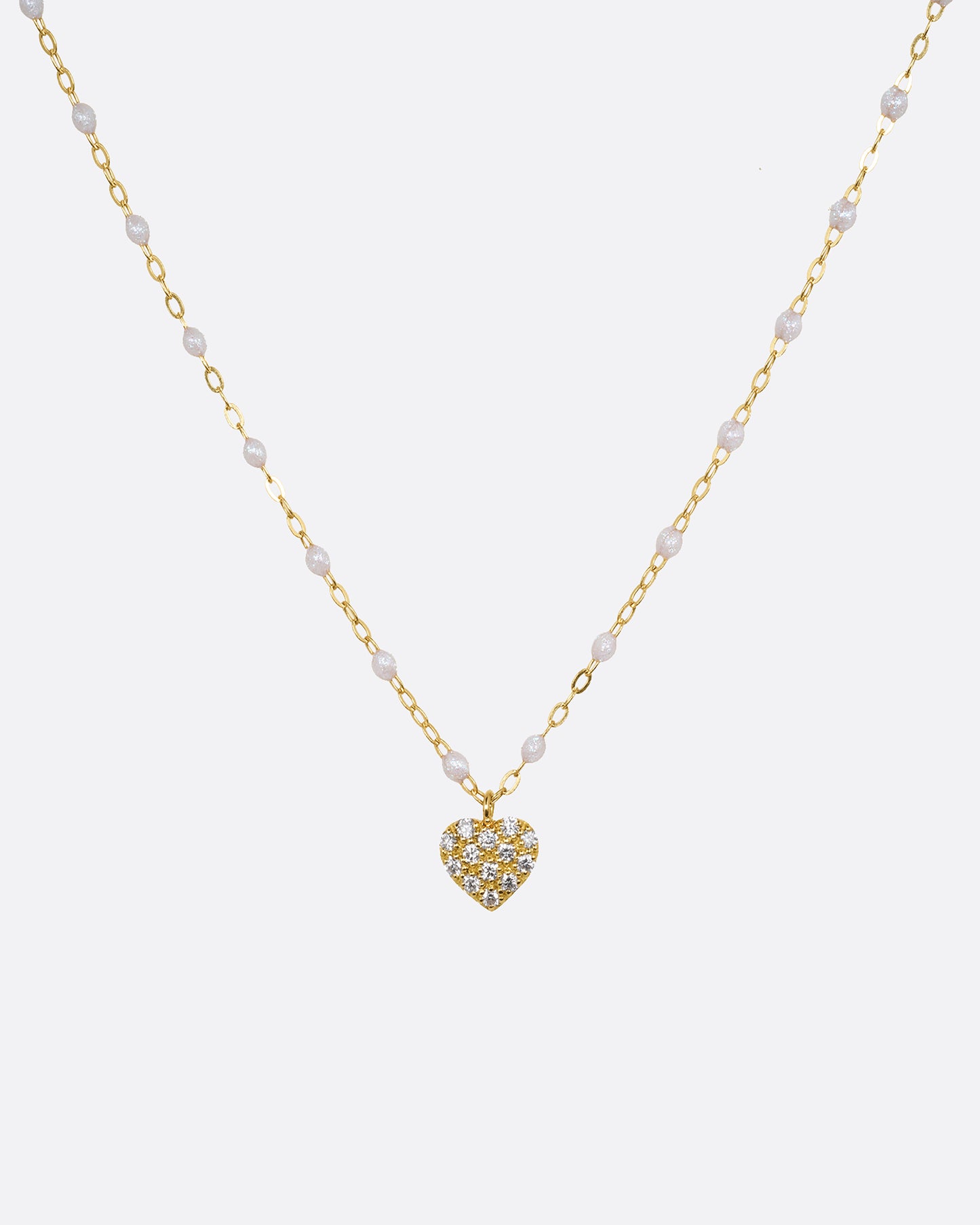 yellow gold necklace with resin and diamond heart charm shown from afar