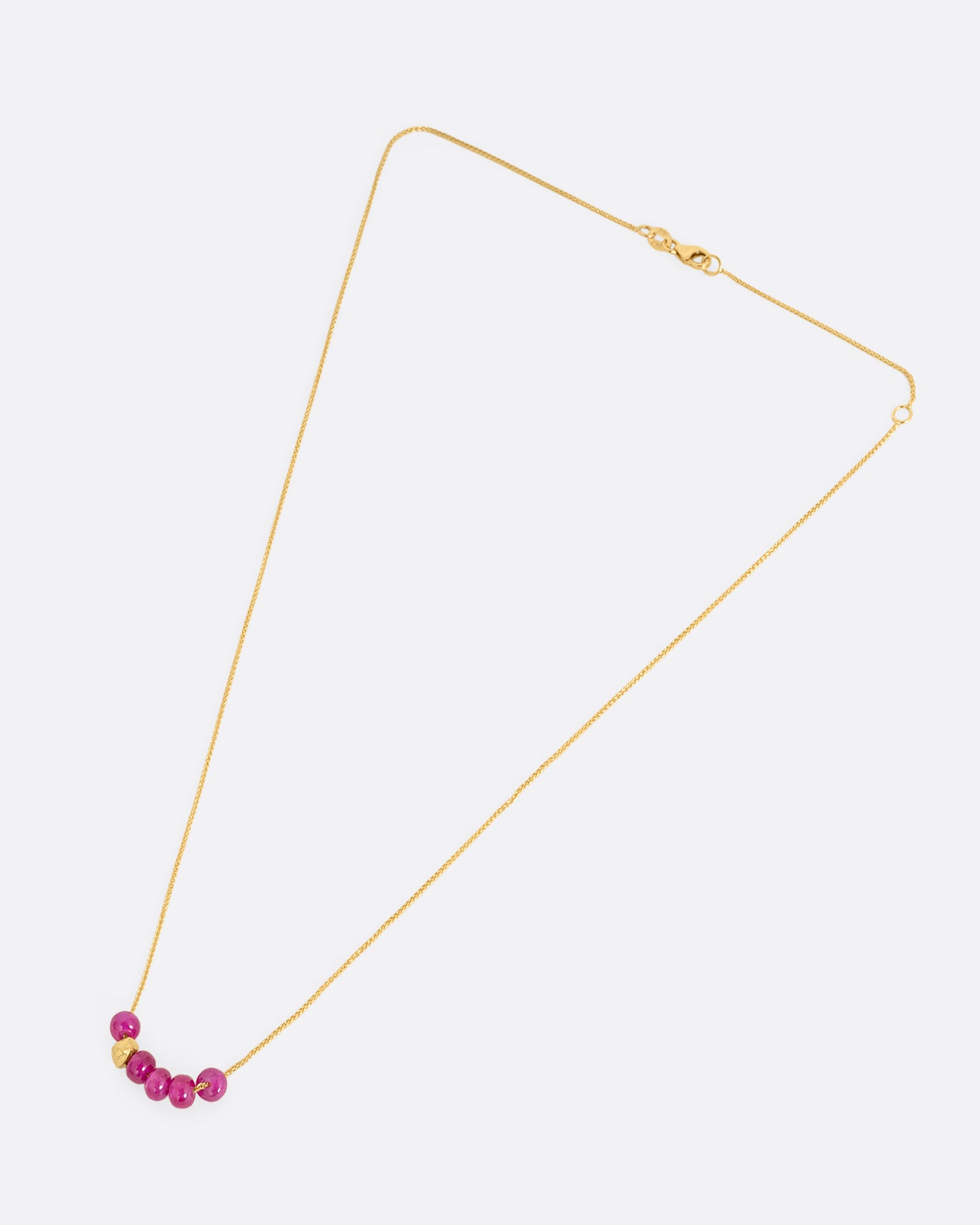 yellow gold necklace with pink sapphire pendant shown horizontally