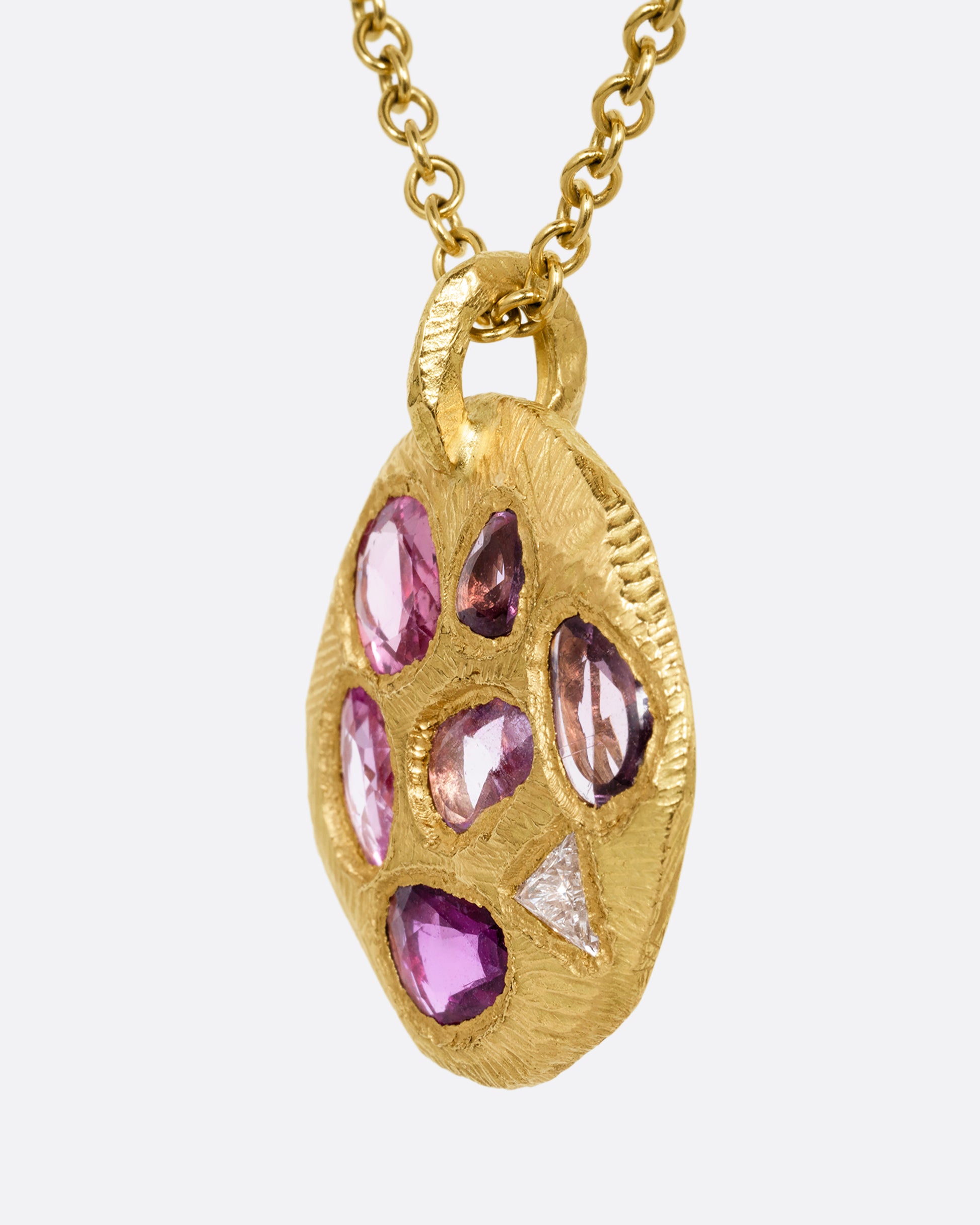 yellow gold necklace with pink sapphire pendant shown from the side