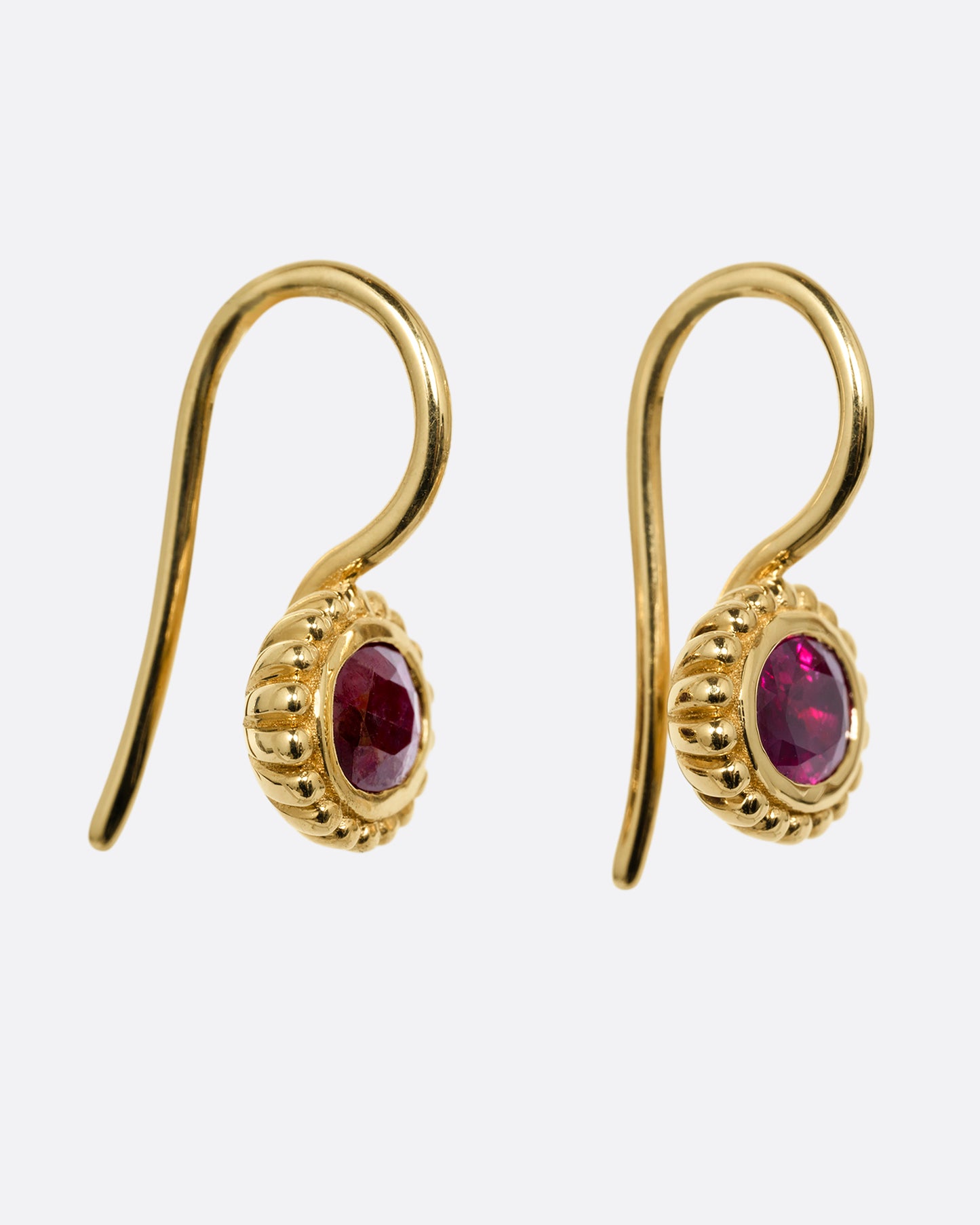 yellow gold ruby earrings shown from the side