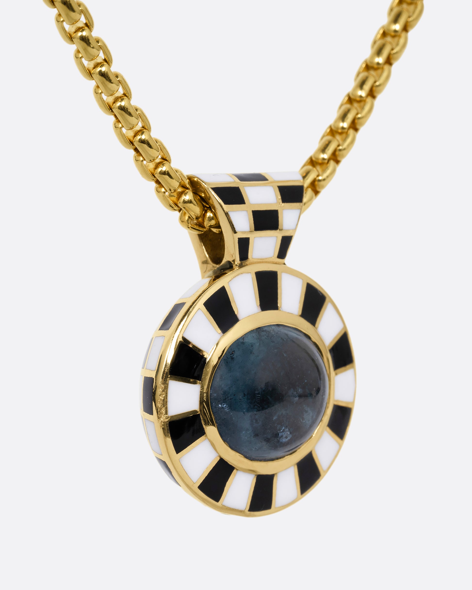 A tourmaline pendant with a black and white enamel checkerboard pattern on a box chain. Shown from the side.