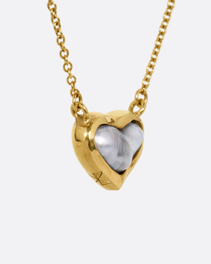 yellow gold necklace with a heart shaped pearl from the side