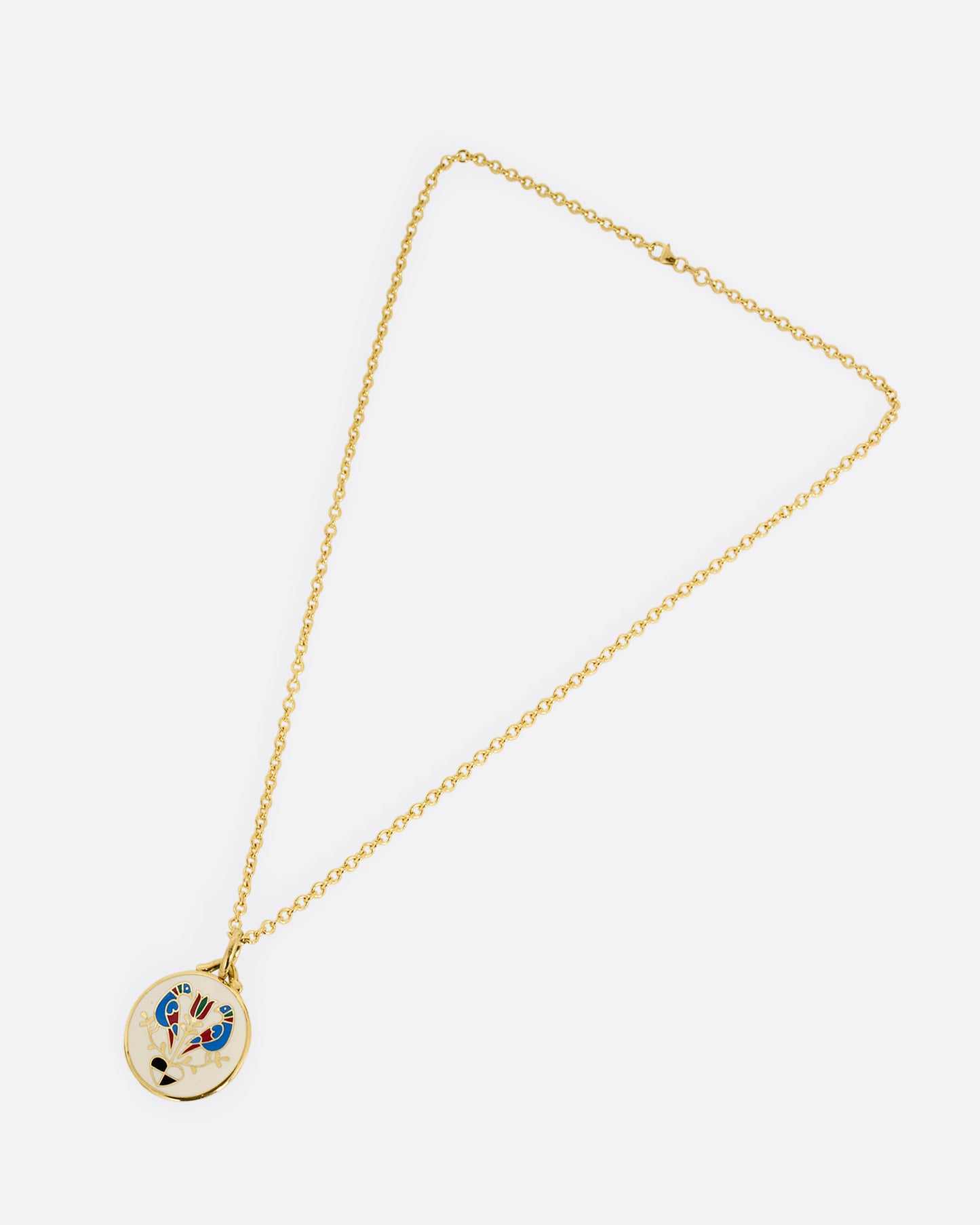 An enamel and yellow gold pendant with a pair of birds, a flower, and a heart on a  cable chain. Shown diagonally from the front.