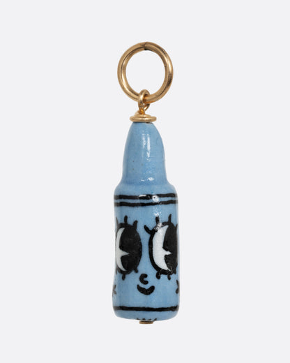 A blue crayon porcelain charm with a yellow gold bail. Shown from the front.