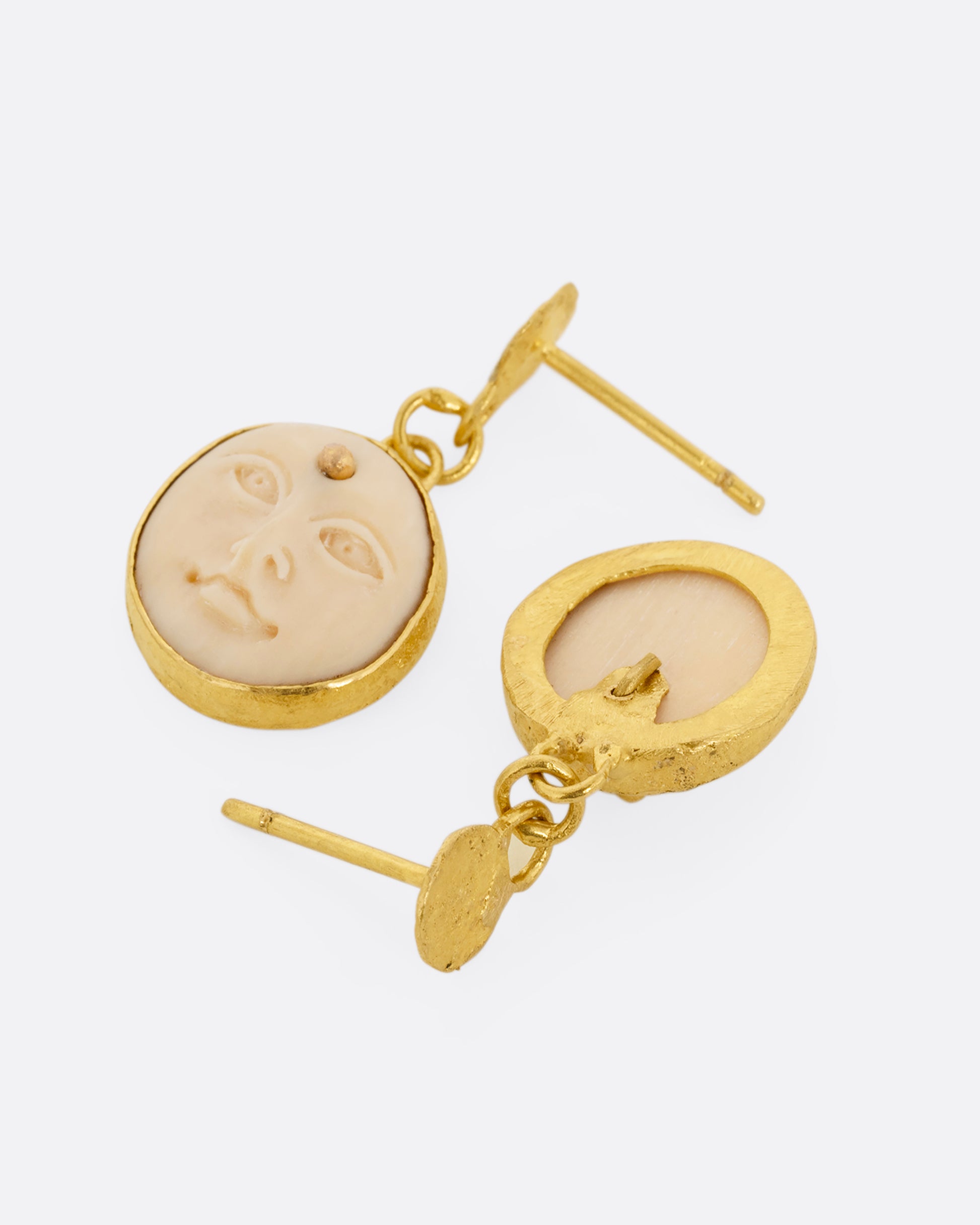 yellow gold carved bone moon face earrings shown from the back
