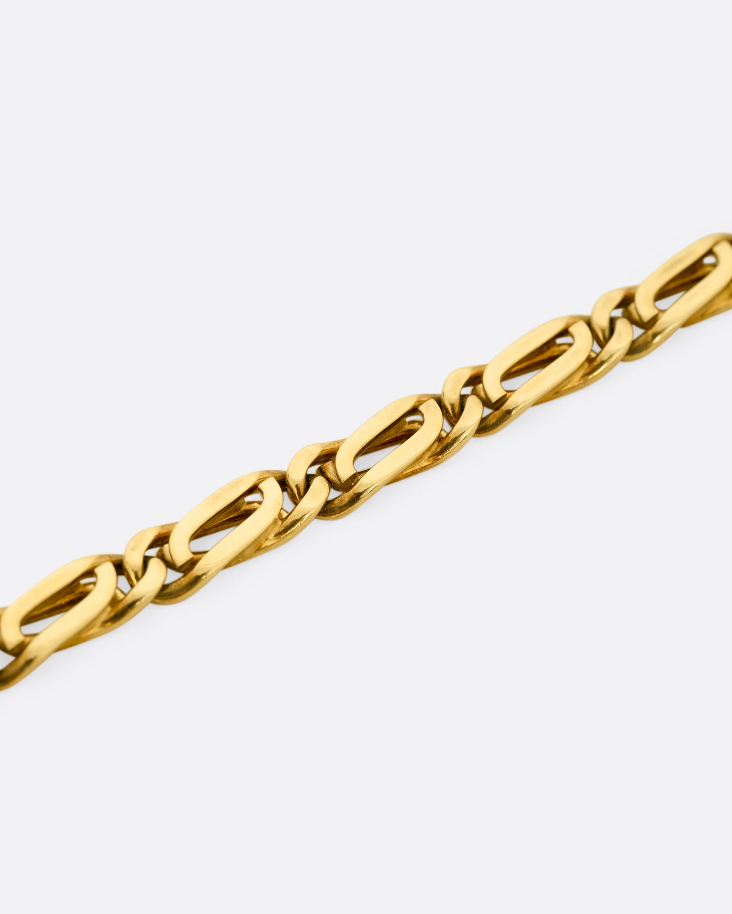 A yellow gold infinity chain link necklace. Shown close up. 