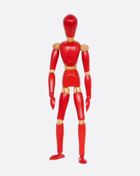 A red wooden articulated human figure. Shown standing from the front.