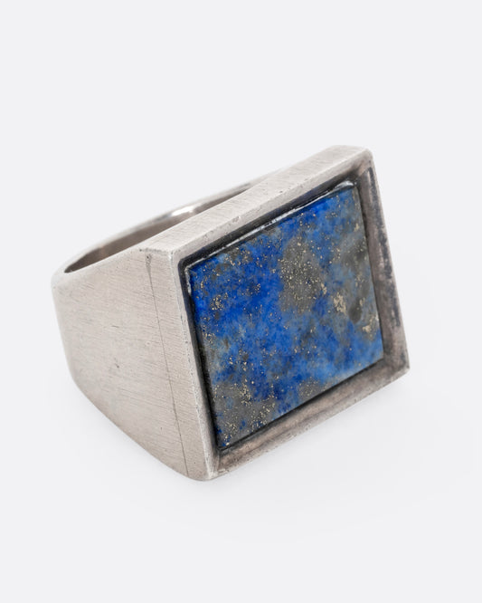 A sterling silver rectangle signet ring with lapis. Shown from the side.