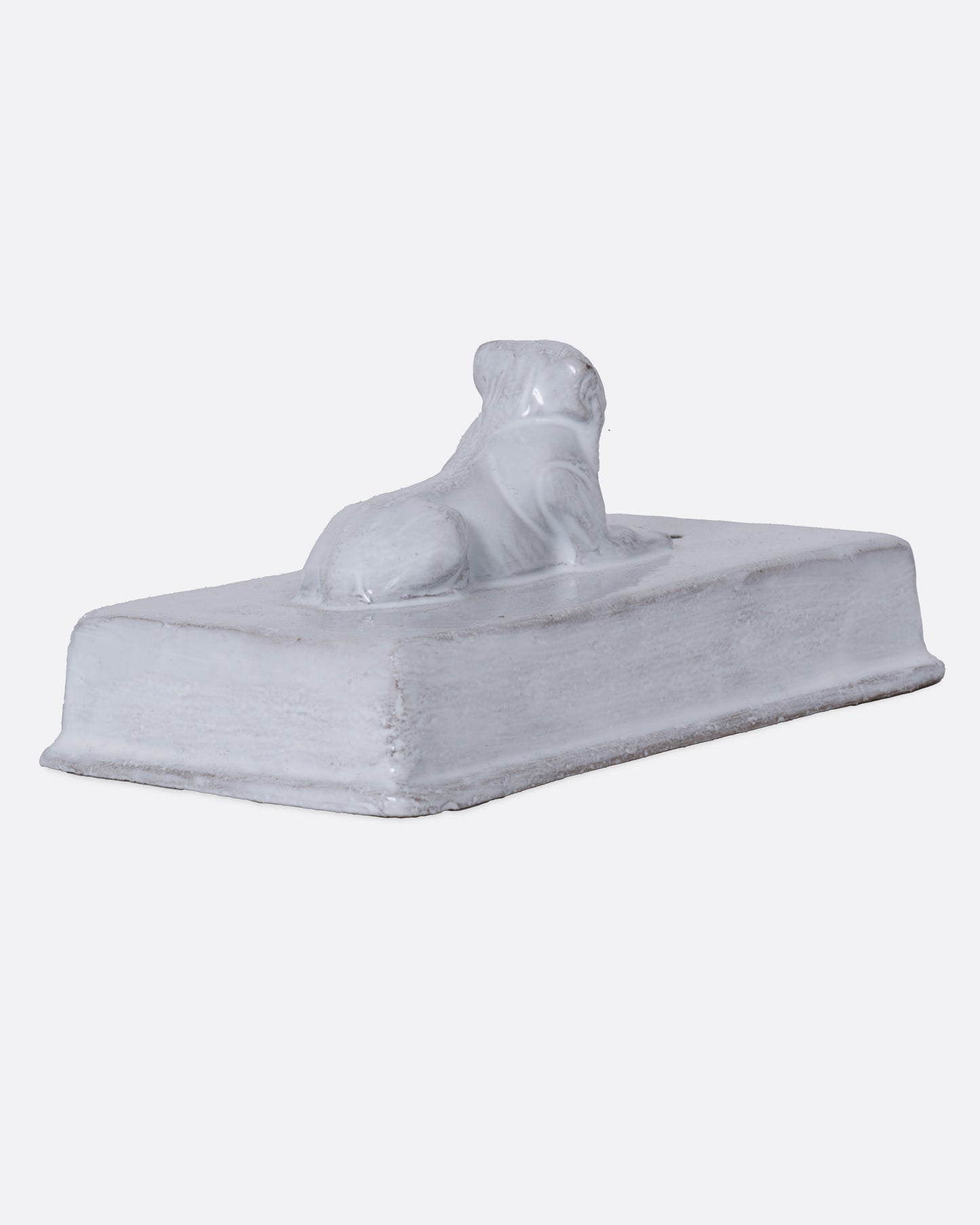 A white rectangular incense holder with a lion on top. Shown from the back.