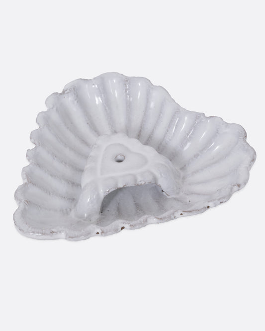 A white heart shaped incense holder, shown from the side. 