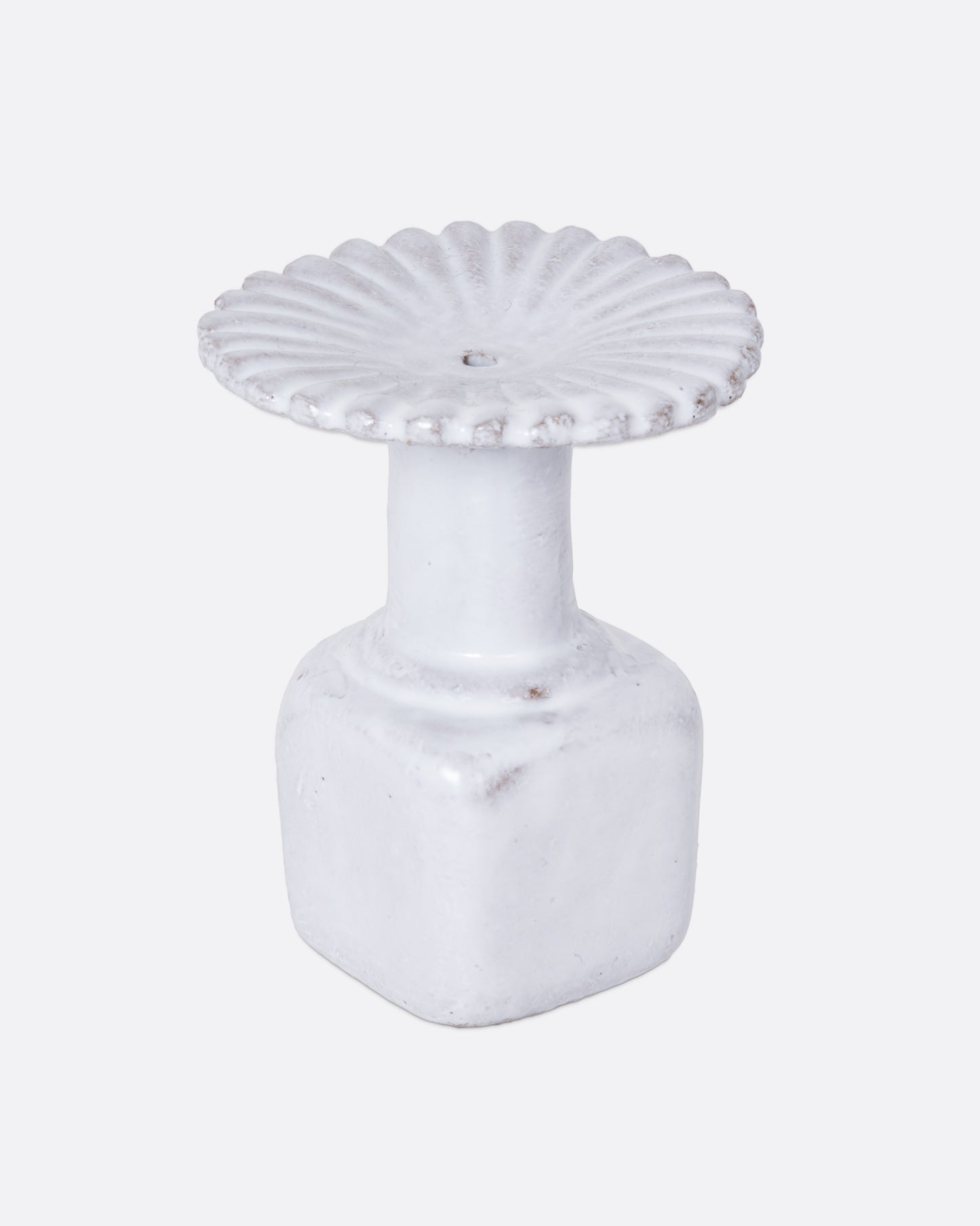  A white ceramic fluted incense holder, shown from the side.