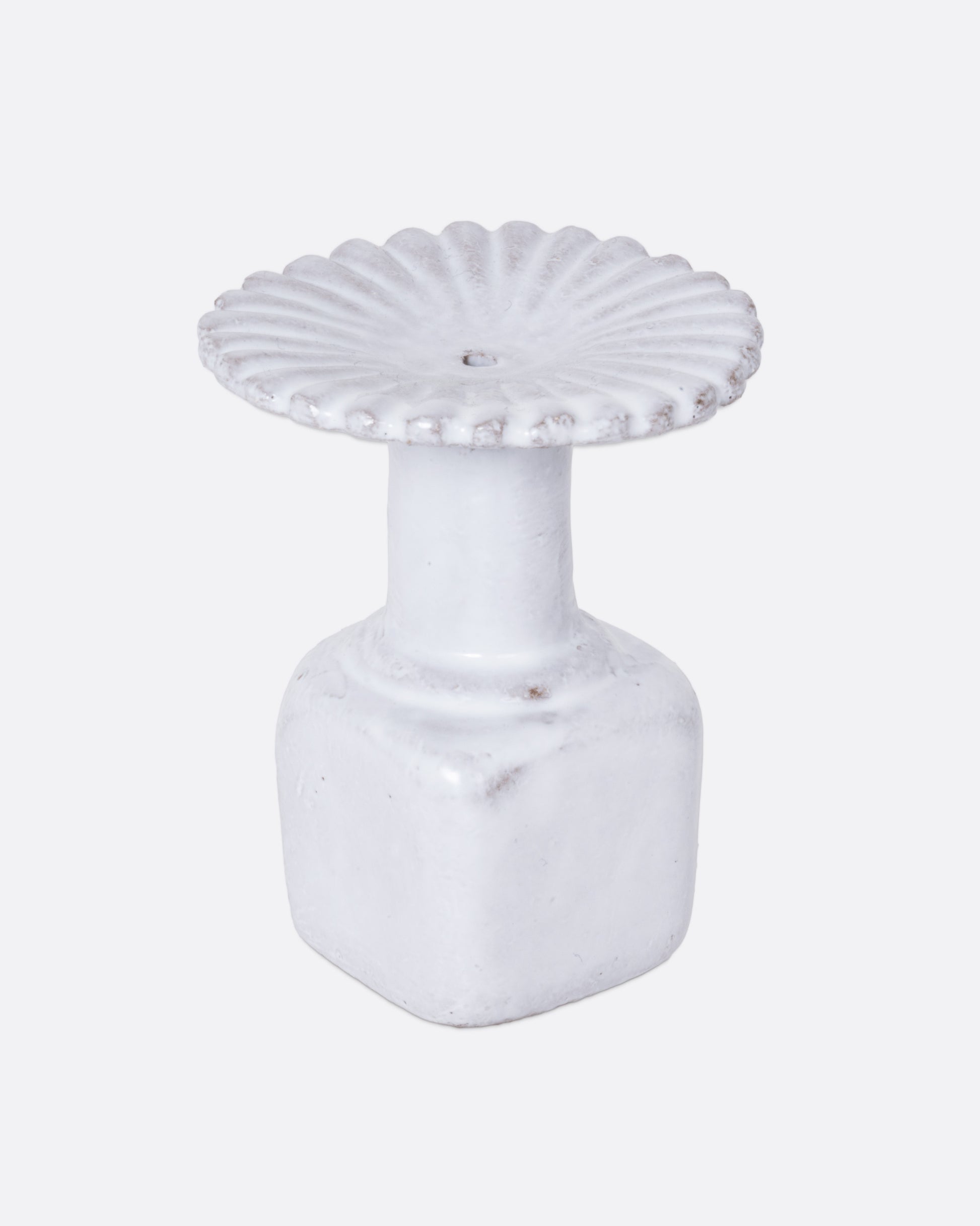  A white ceramic fluted incense holder, shown from the side.