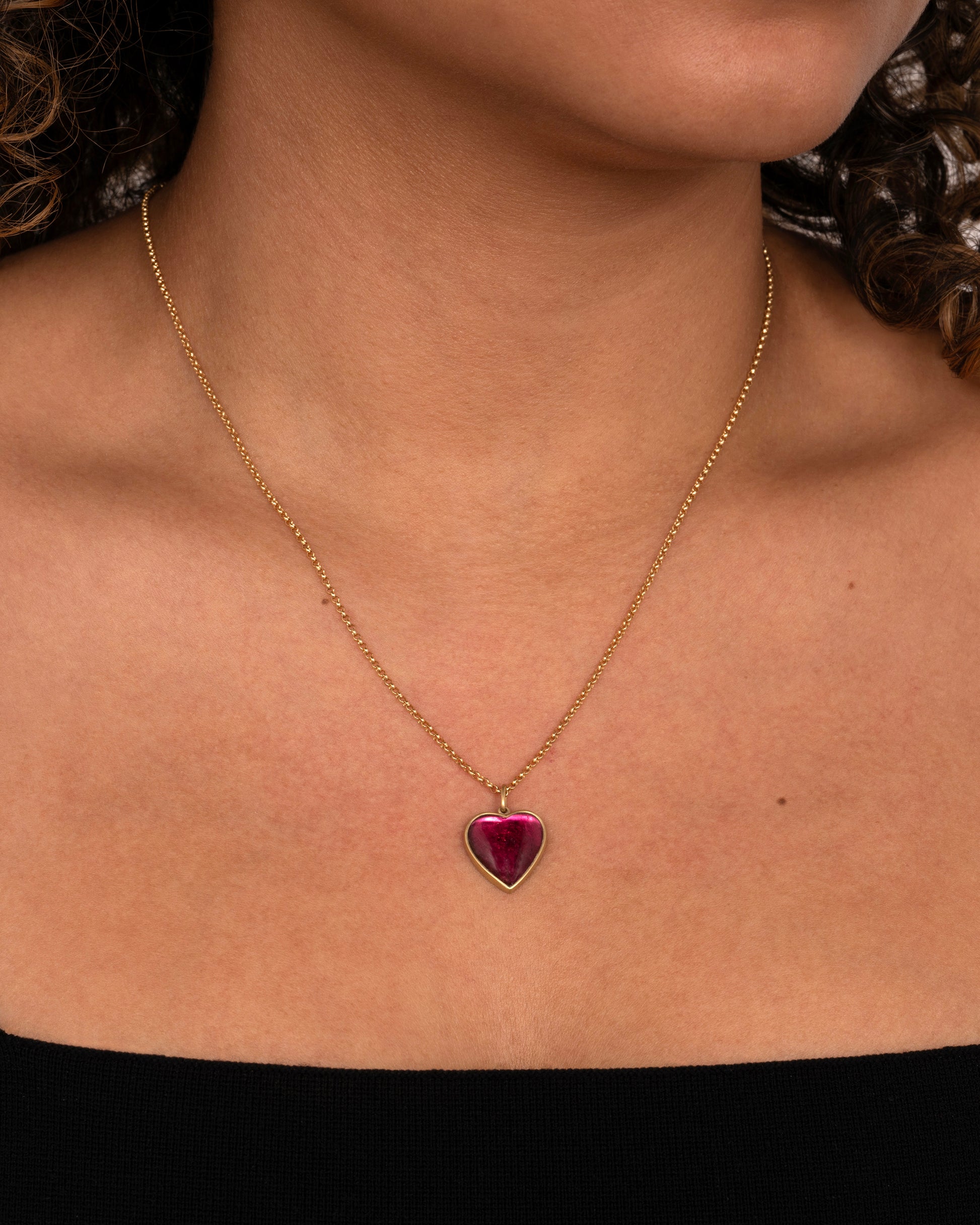 yellow gold necklace with a heart shaped tourmaline shown worn around the neck