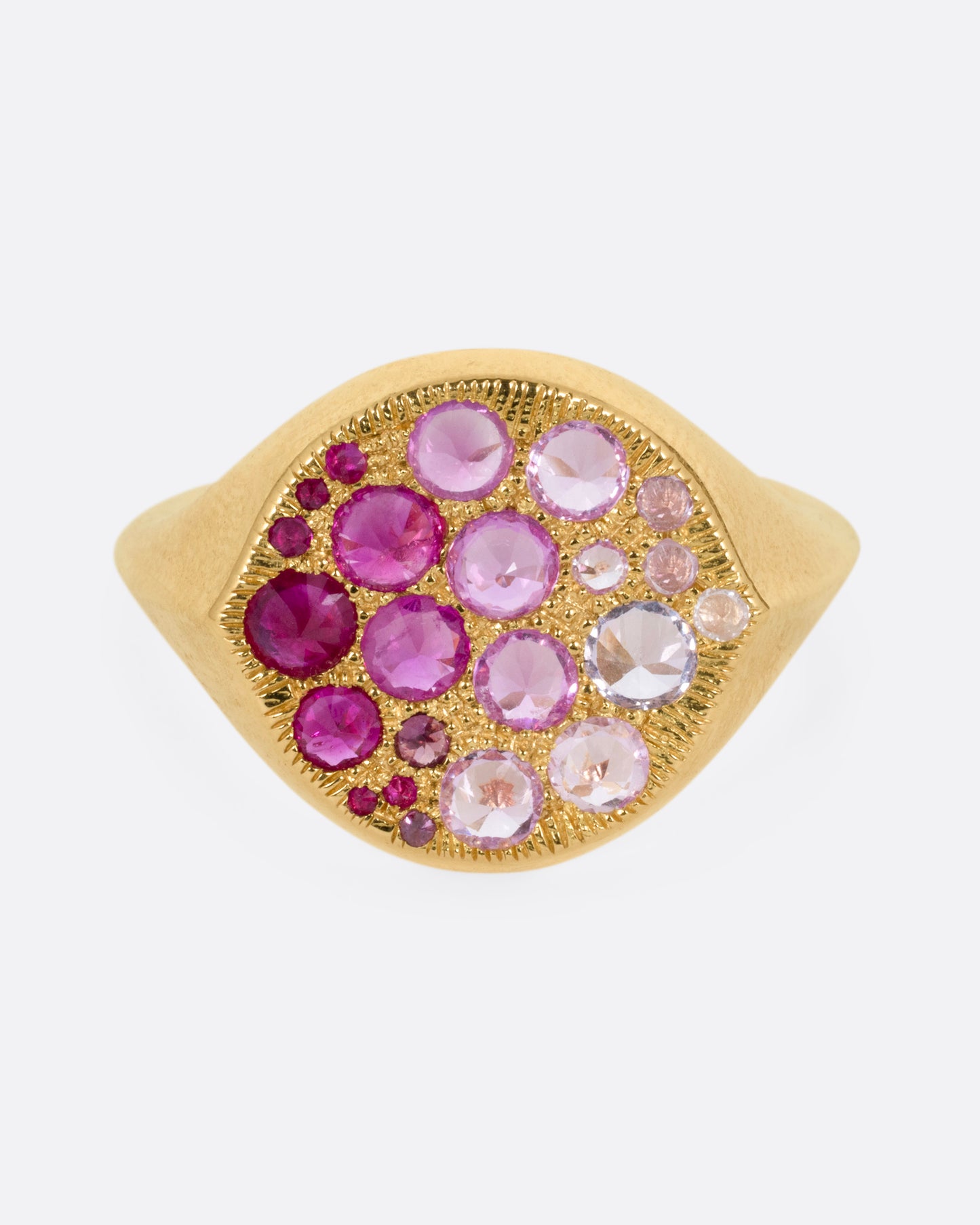 A yellow gold signet eye-shaped ring with an ombré of reverse set sapphires and rubies. Shown from the front.