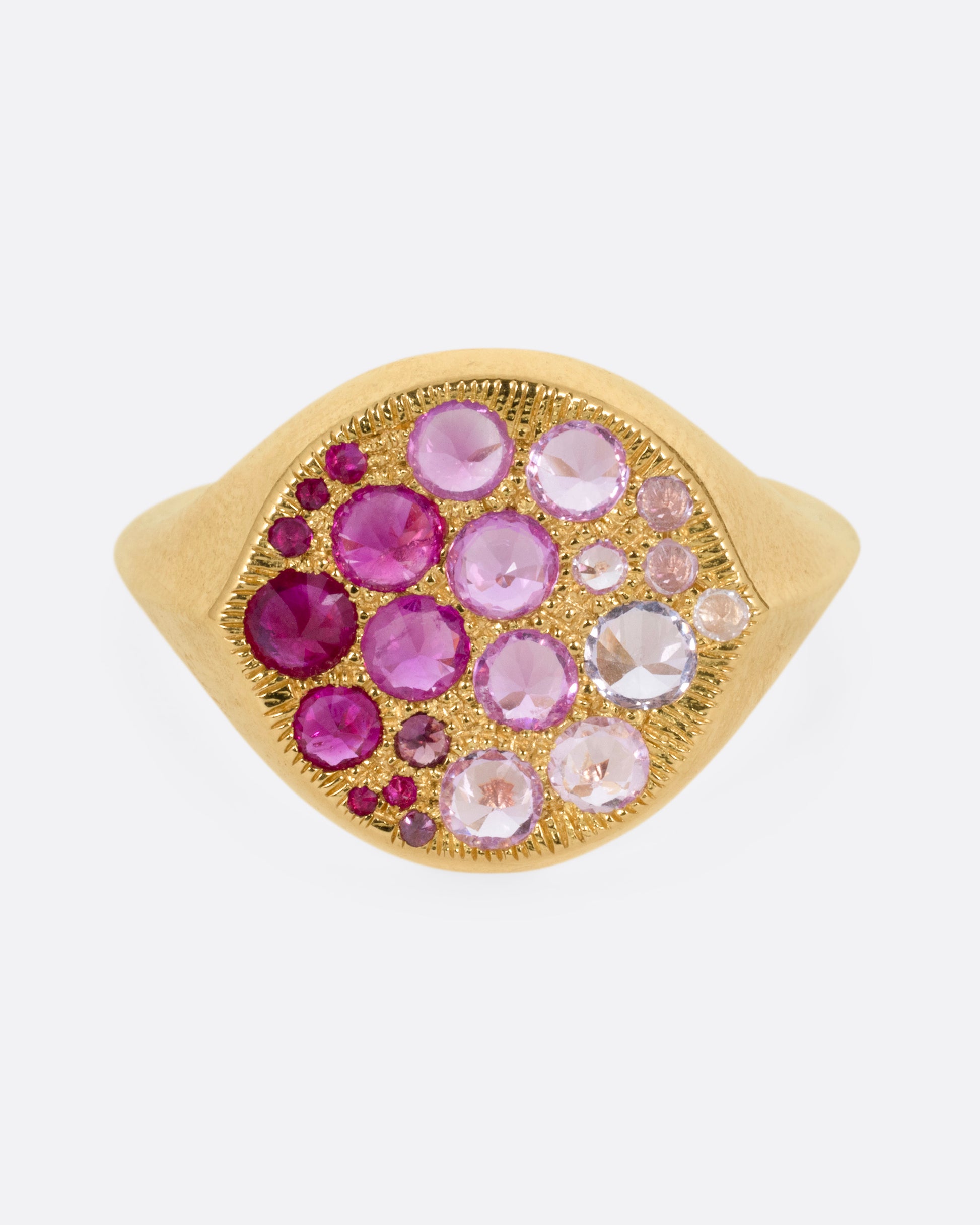 A yellow gold signet eye-shaped ring with an ombré of reverse set sapphires and rubies. Shown from the front.