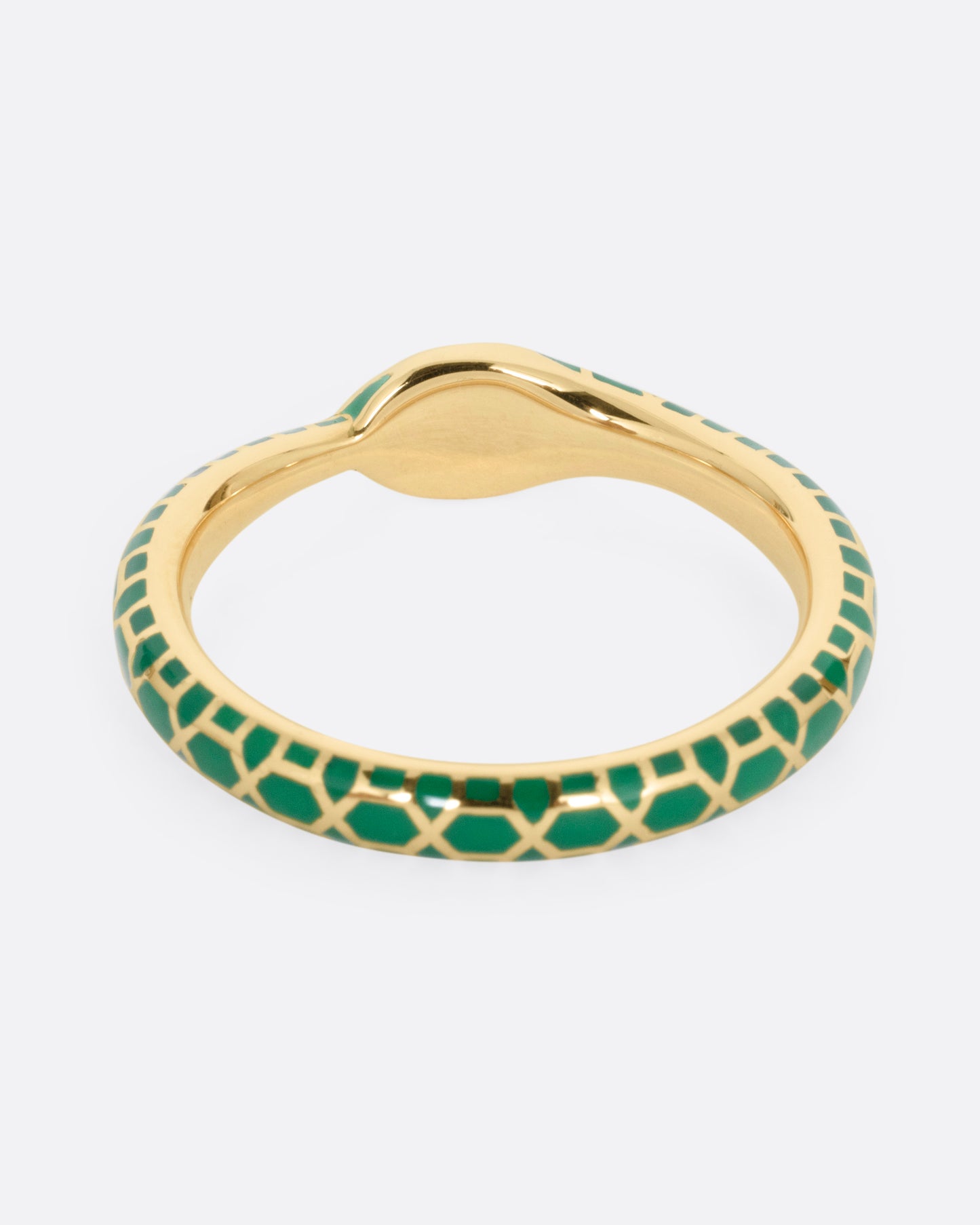 A yellow gold  ouroboros ring with sapphire eyes and a green enamel snake skin pattern, shown from the back.
