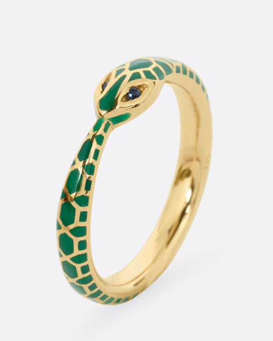 A yellow gold  ouroboros ring with sapphire eyes and a green enamel snake skin pattern, shown standing up from the side.