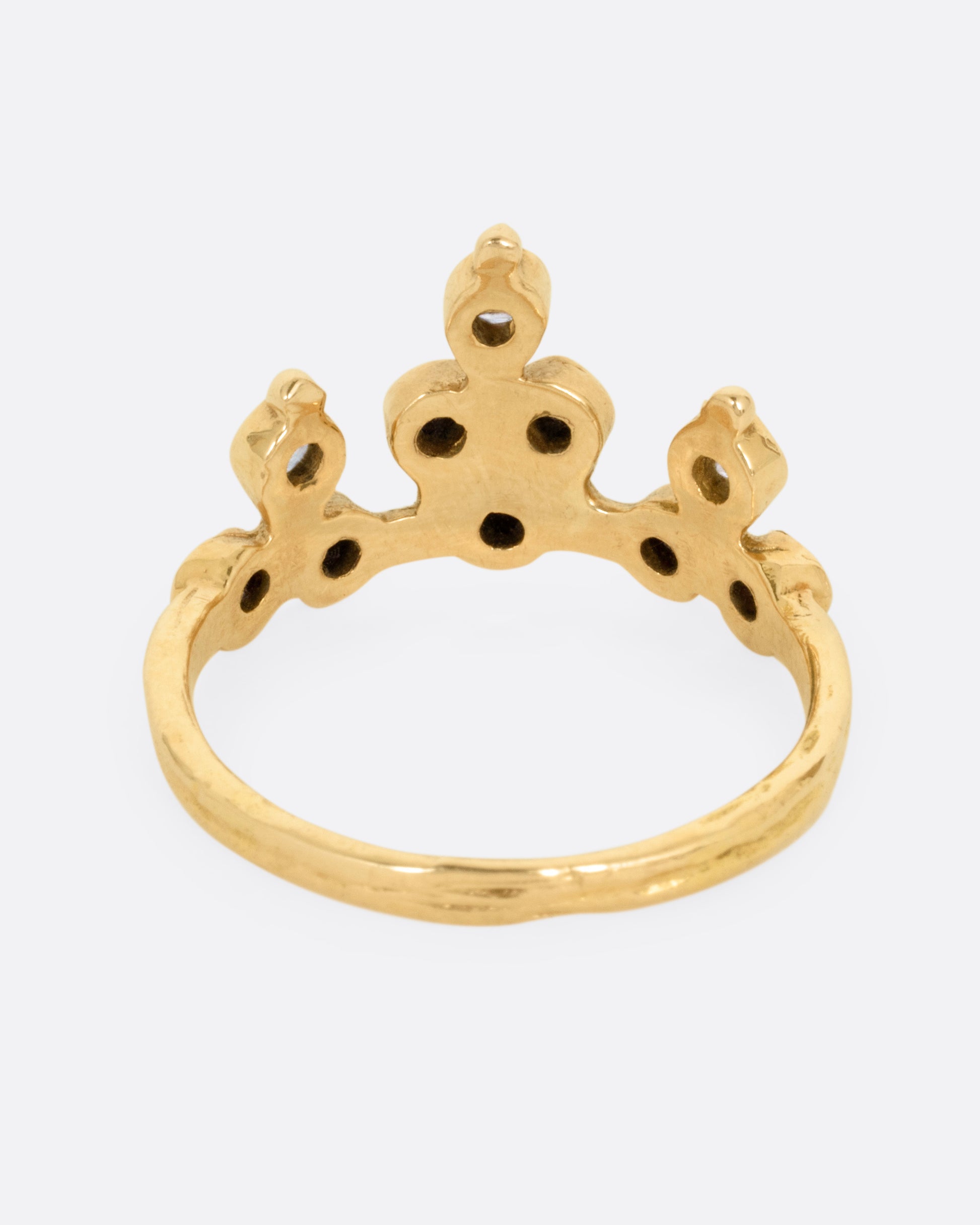 A yellow gold tiara ring with white and black diamonds, shown from the back.