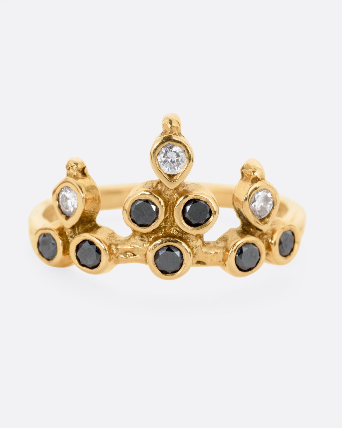 A yellow gold tiara ring with white and black diamonds, shown from the front.