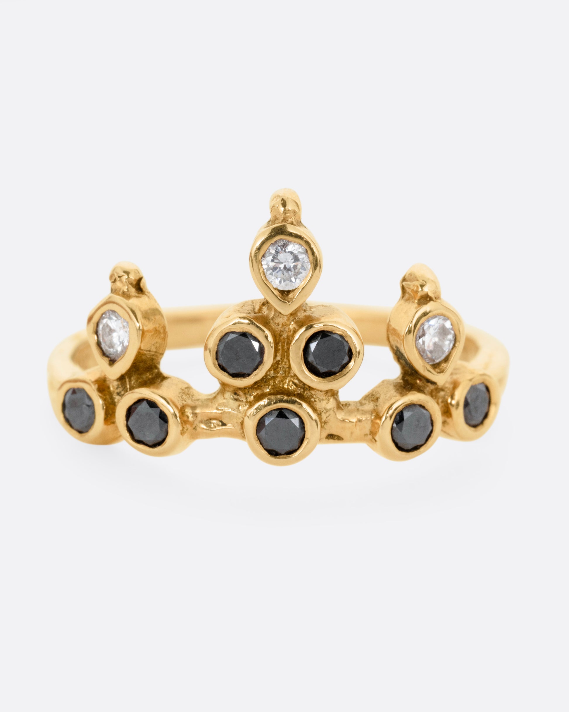 A yellow gold tiara ring with white and black diamonds, shown from the front.