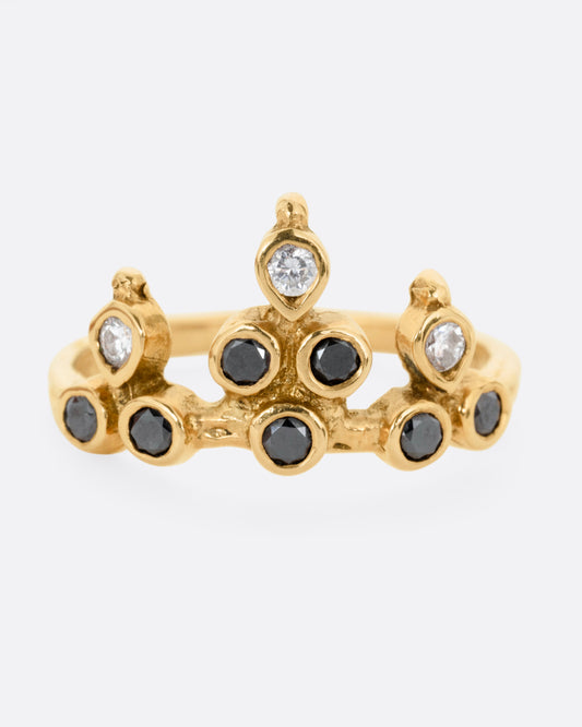 A yellow gold tiara ring with white and black diamonds, shown from the front.