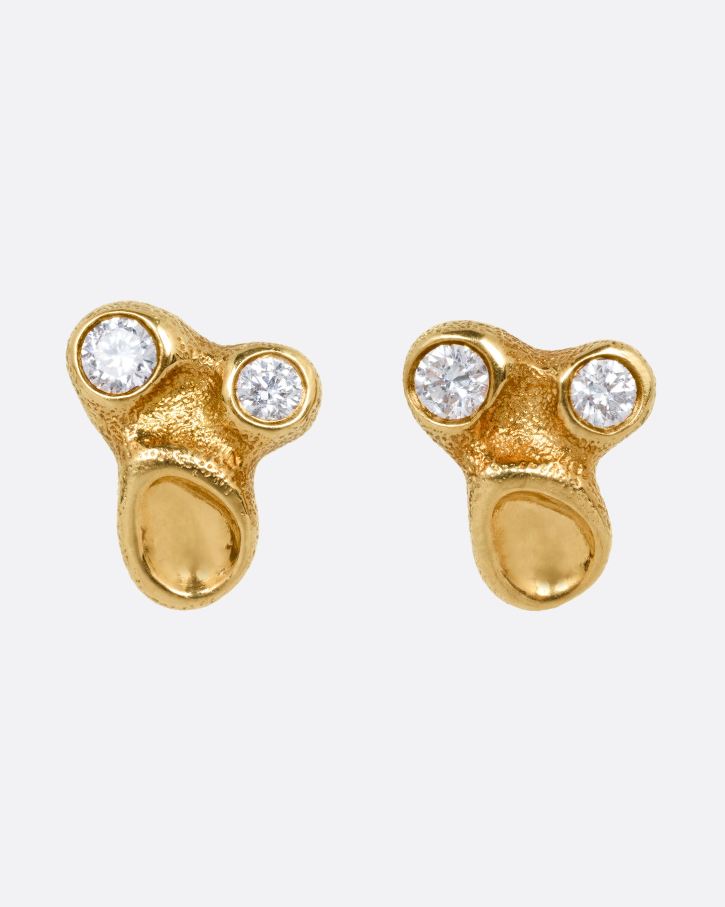 A pair of yellow gold stud earrings with two bezel set diamonds and smooth depressions, shown from the front.