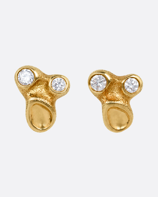 A pair of yellow gold stud earrings with two bezel set diamonds and smooth depressions, shown from the front.