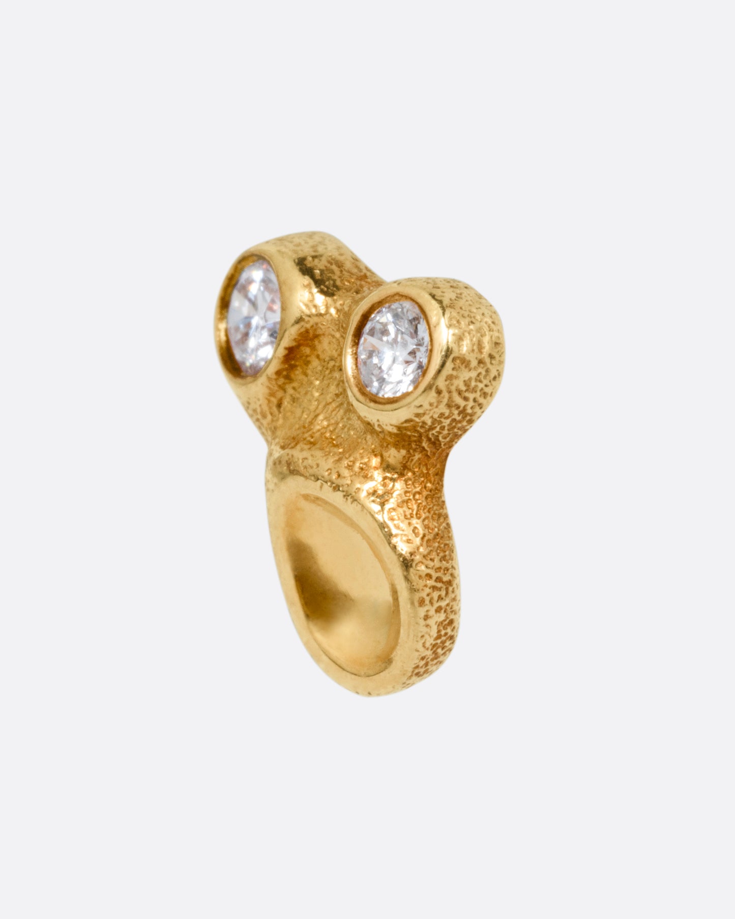 A yellow gold stud earring with two bezel set diamonds and smooth depressions, shown from the side.