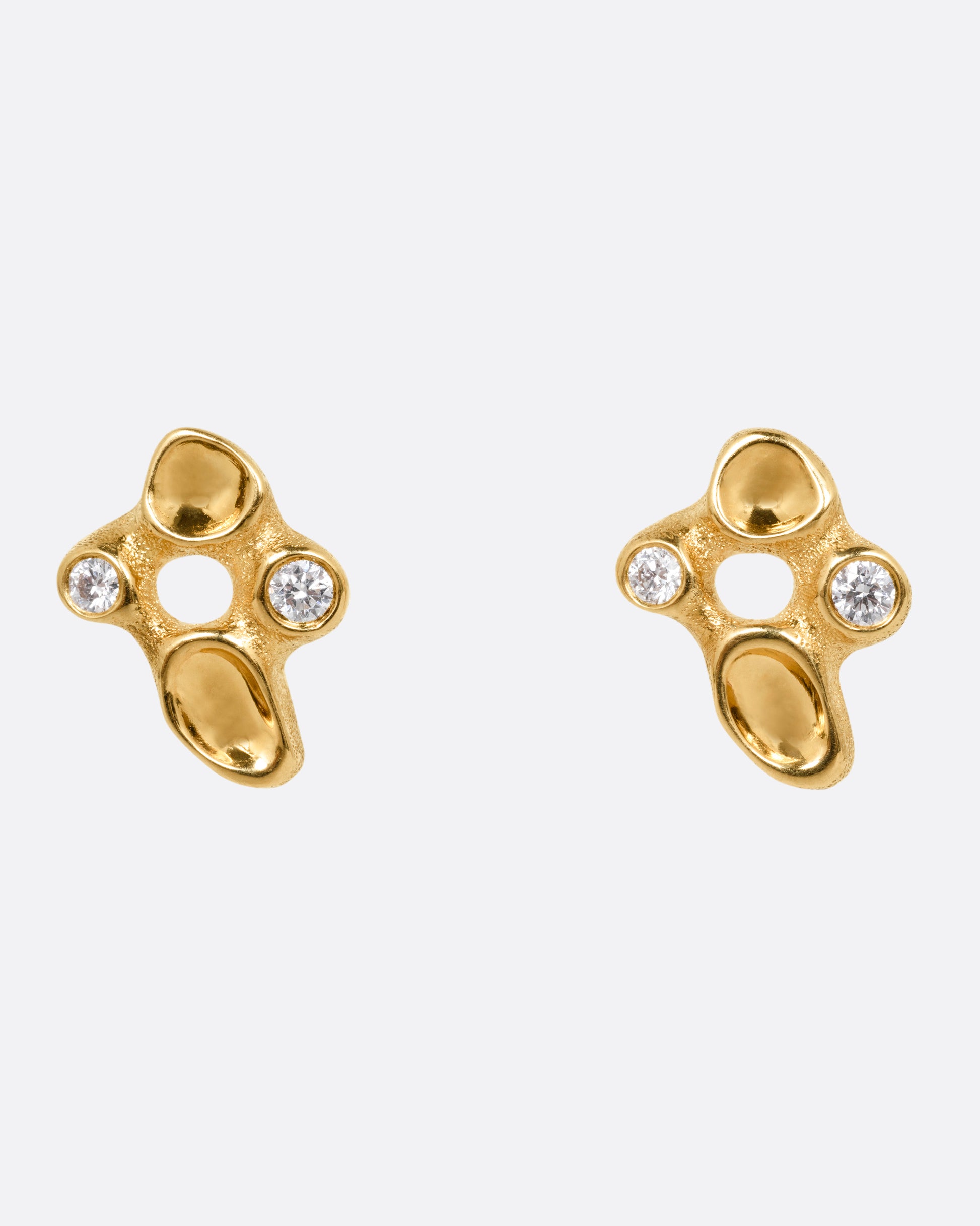 A pair of yellow gold cluster stud earrings with diamonds and smooth depressions, shown from the front.
