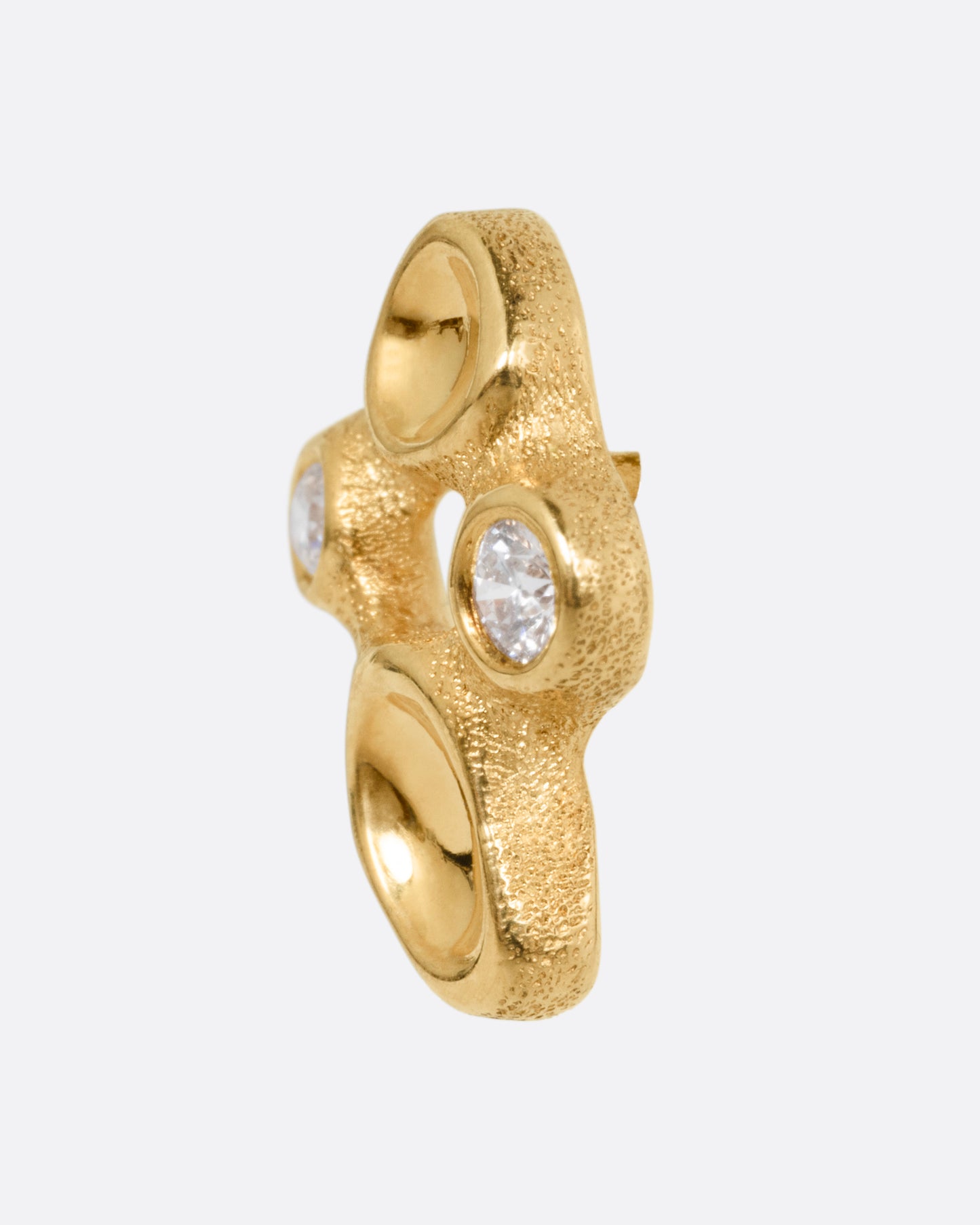 A yellow gold cluster stud earring with diamonds and smooth depressions, shown from the side.