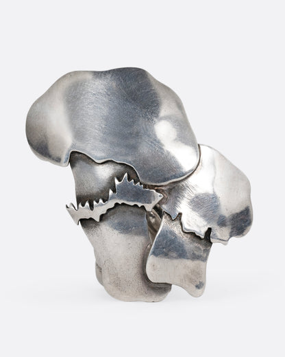 A silver pin with two mushrooms. Shown from the front.