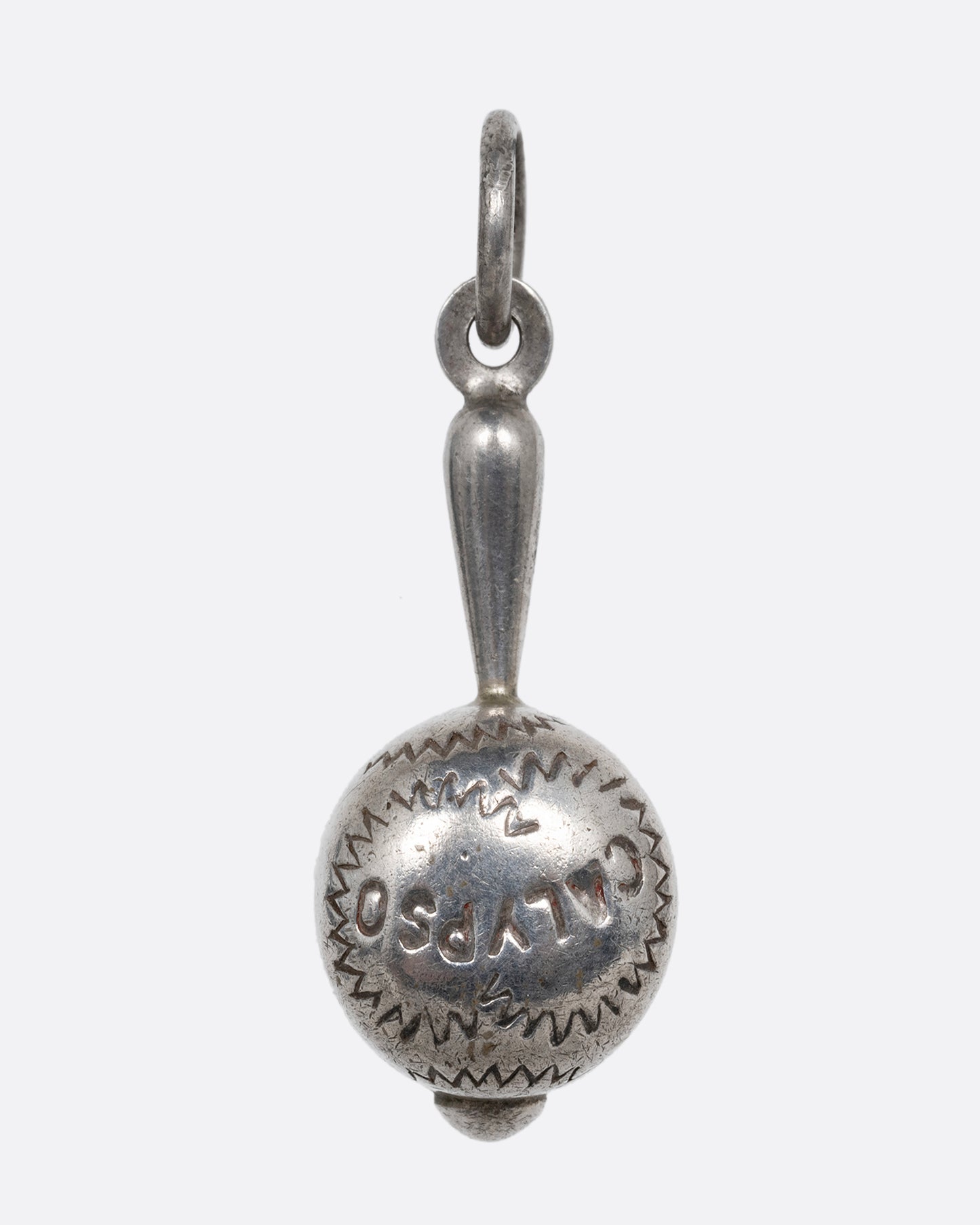 A silver maraca charm with 'Calypso' engraved on it. Shown from the front.