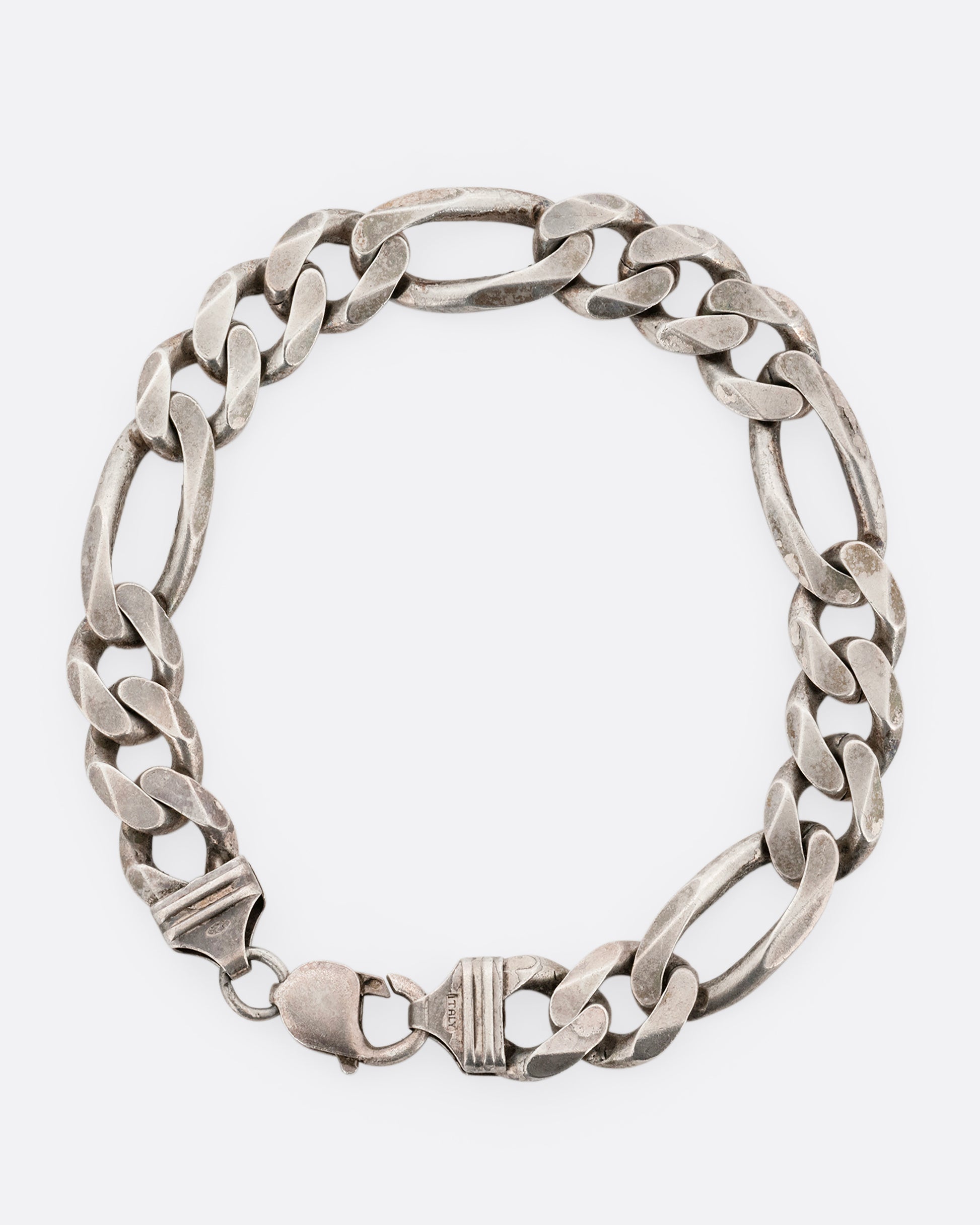 A wide silver figaro chain bracelet. Shown from the top.