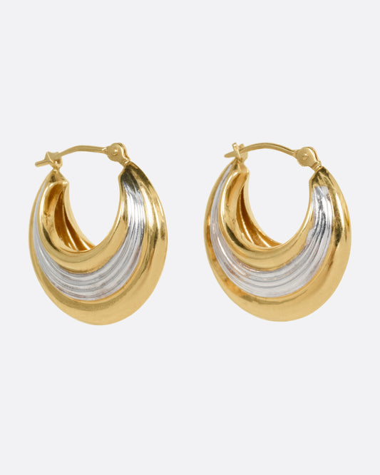 A pair of yellow gold and silver hoop earrings, shown from the side.