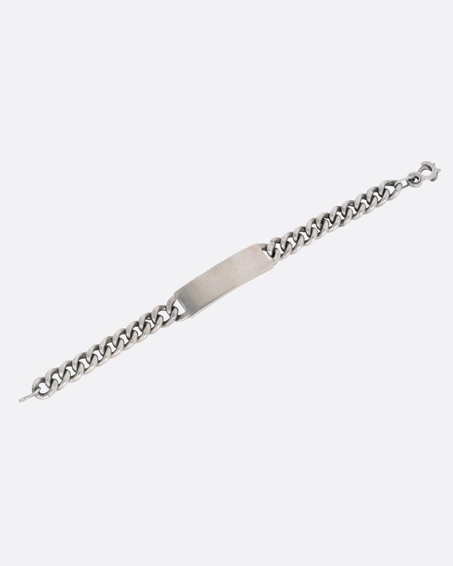 A silver curb chain ID bracelet, shown open from the front.
