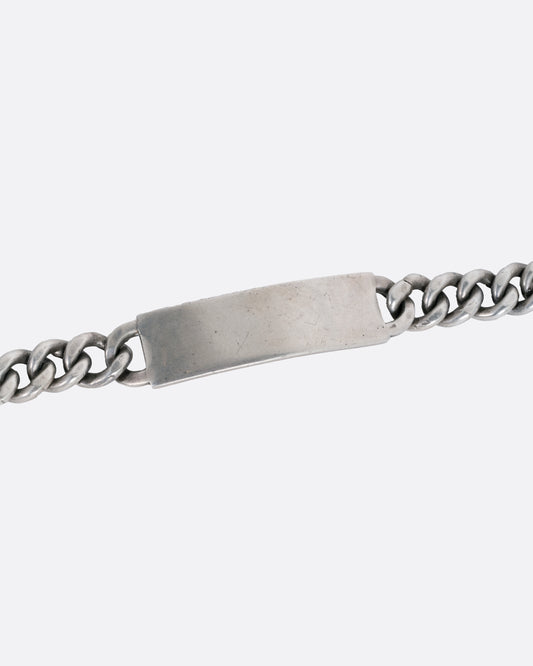 A silver curb chain ID bracelet, shown from the front.