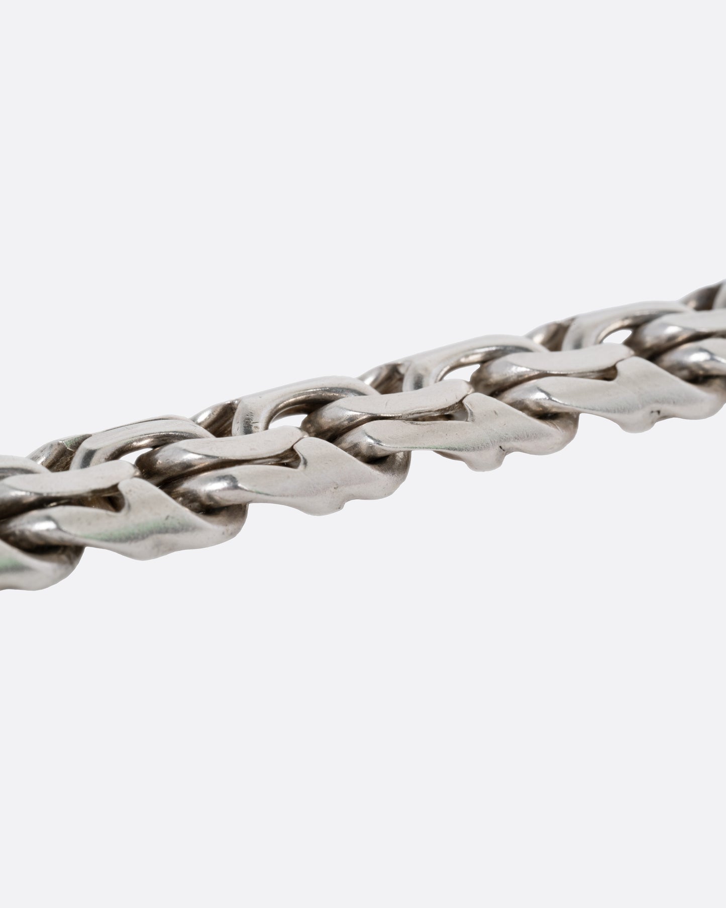 A close up of a silver flat double link bracelet.