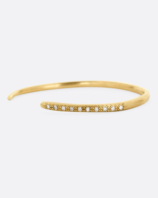 A yellow gold open cuff bracelet with diamonds. Shown from the front.