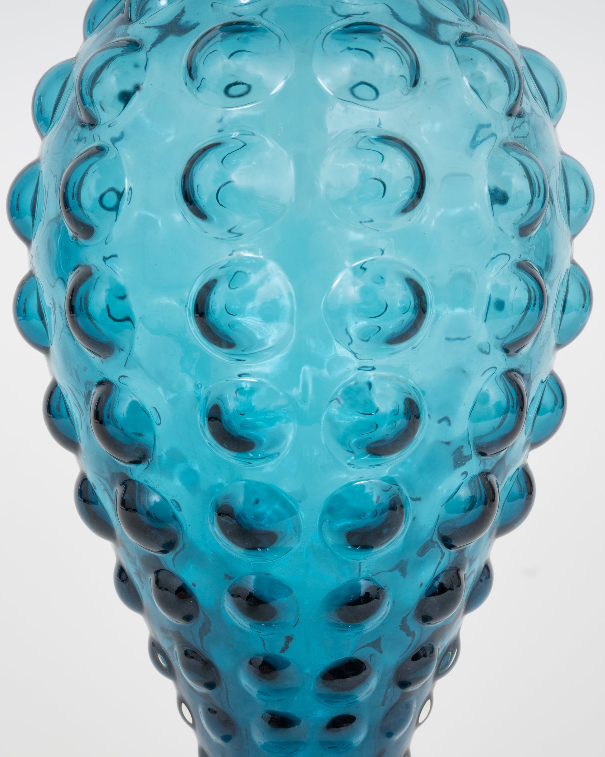 A teal hourglass glass vase with a bubbled texture. Shown close up from the front.