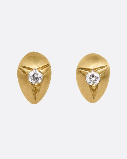 Yellow brushed gold teardrop shaped earrings with white diamonds at the center. Shown from the front.