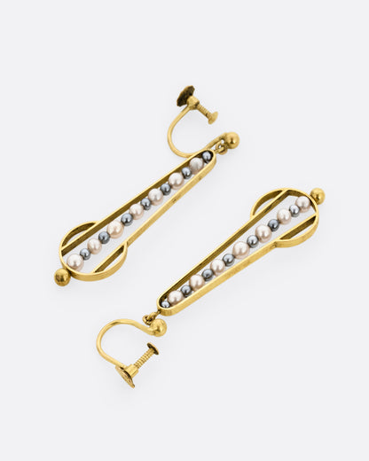 Yellow gold geometric dangle earrings with screw clasps and pearls down the center. Shown lying flat; one from the front, one from the back.